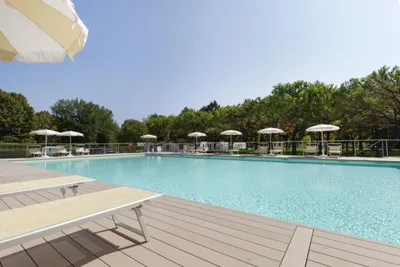 Camping Fusina - Swimmingpool mit Liegestühlen und Sonnenschirmen am Rand