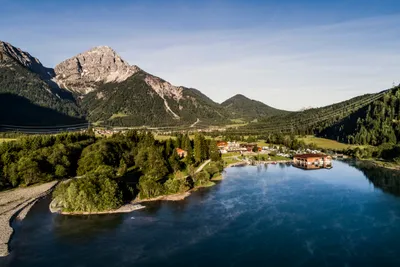 Camping Heiterwanger See - Blick auf den Campingplatz am See mit Berglandschaft im Hintergrund