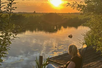Camping Hiddema State - Camperin genießt die Aussicht auf das Wasser bei Sonnenuntergang