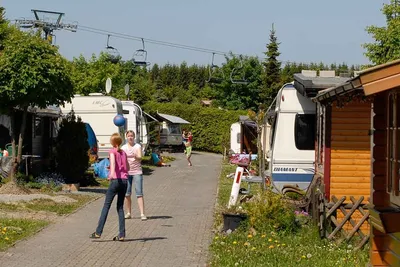 Campingpark Hochsauerland  - spielende Kinder auf dem Wohnwagen- und Zeltstellplatz vom Campingplatz, Lift im Hintergrund