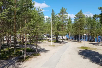 Camping Hossan Lumo  -  Stellplatz vom Campingplatz zwischen Bäumen mit Blick auf den See