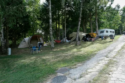 Camping l'Aventure - Standplätze unter Bäumen auf dem Campingplatz