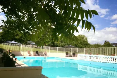 Camping L'Orée du Lac - Pool mit Liegestühlen und Sonnenschirmen auf dem Campingplatz