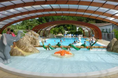 Der Außenpool des Camping La Grainetière und Kinderbecken mit Rutsche sowie teleskopischer Schwimmbadüberdachung.
