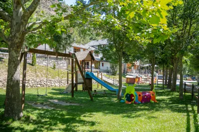 Camping La Mola - Spielplatz unter Bäumen auf dem Campingplatz