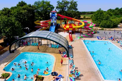 Camping Lac de Ribou - Poolbereich mit Wasserrutschen und Liegestühlen auf dem Campingplatz