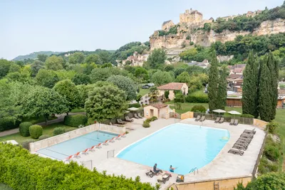 Camping Le Capeyrou - Pool mit Liegestühlen und Sonnenschirmen auf dem Campingplatz