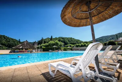 Camping Le Gibanel  -  Pool vom Campingplatz mit Sonnenschirmen und Liegestühlen