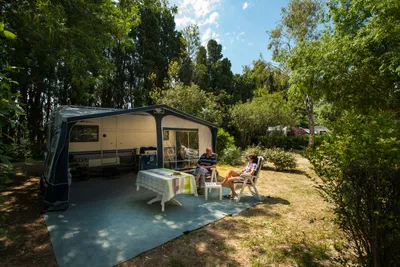 Camping Le Haras -  Wohnmobilstellplatz zwischen Bäumen auf dem Campingplatz