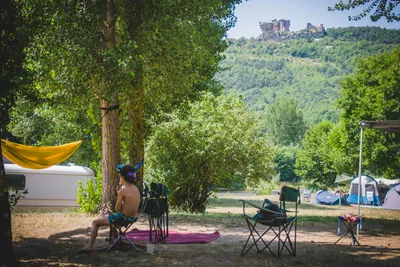 Camping le Moulin de la Galinière - ein junger Gast sitzt auf dem Stellplatz.