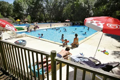 Campin le Moulin de Mellet - Poolbereich vom Campingplatz mit Liegestühlen und Sonnenschirmen