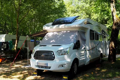 Camping Le Péquelet Wohnmobilstellplatz unter Bäumen auf dem Campingplatz