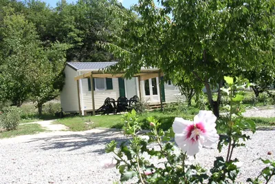 Camping Le Pilat - Mobilheim mit Veranda zwischen Bäumen