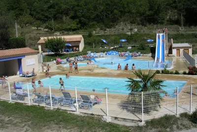 Camping Le Pilat - Swimmingpools auf dem Campingplatz mit Rutsche, Liegen am Rand und Liegewiese mit Sonnenschrimen