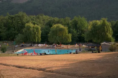 Camping Le Querce - Blick auf den Swimmingpool des Campingplatzes mit Sonnenliegen am Rand