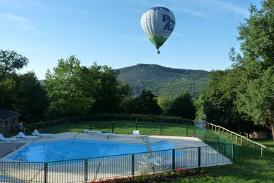 Camping Le Viginet - Campingplatz Pool und Heißluftballon am Himmel