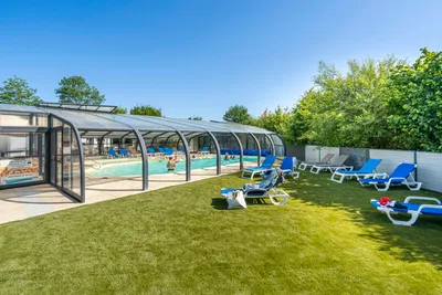 Camping Les Charmes - Überdachter Pool mit Liegestühlen auf dem Campingplatz