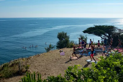 Camping Castels Les Criques de Porteils -  Gäste entspannen beim Yoga im Schatten am Strand mit Blick auf das Mittlmeer