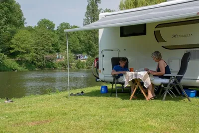 Camping Les Rochers des Parcs - Camper sitzen vor ihrem Wohnmobil auf einem Standplatz