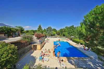 Camping Les Terrasses du Périgord   -  Camper am Pool vom Campingplatz mit Liegestühlen in der Sonne