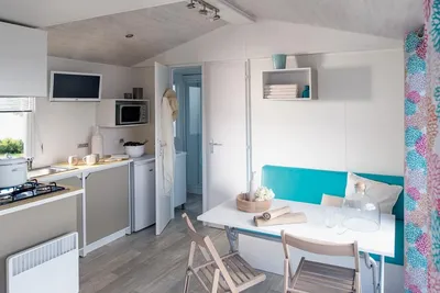 Camping Les Tilleuls - Innenraum eines Mobilheims mit Kochecke und Esstisch
