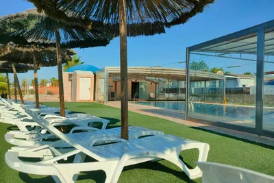 Camping Los Delfines - Liegestühle und Sonnenschirme am Pool