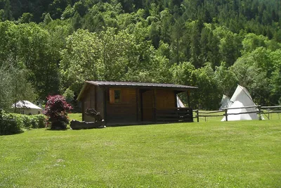 Camping Lou Dahu - Ferienhütte aus Holz mit überdachter Veranda auf dem Campingplatz