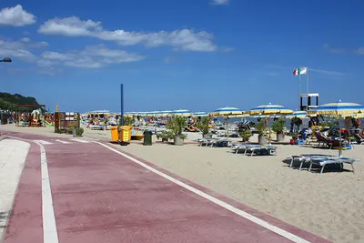 Camping Marinella  - Strand vom Campingplatz am Mittelmeer mit Sonnenschirmen und Liegestühlen