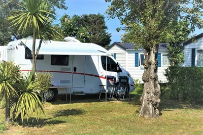 Camping Mon Calme - Wohnwagenstellplatz auf grüner Wiese neben Mobilheimen auf dem Campingplatz