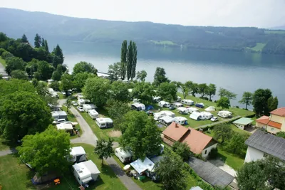 Camping Neubauer - Luftaufnahme auf die Wohnwagen- und Zeltstellplätze und den Millstättersee im Hintergrund