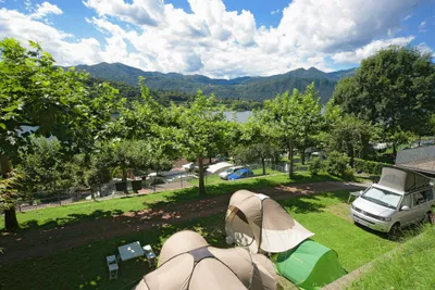 Camping Orta - Zelte und Campingbulli auf Stellplätzen im Grünen
