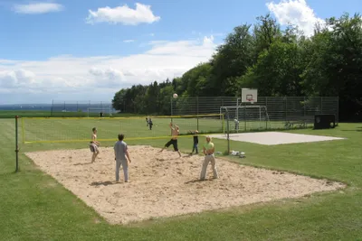 Camping Walkyrien  -  Volleyball spielende Camper auf Volleyballfeld vom Campingplatz, die Ostsee im Hintergrund