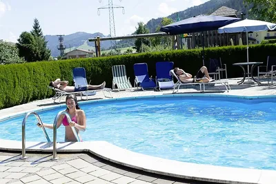 Camping Passrucker - Pool des Campingplatzes mit Liegestühlen und Sonnenschirmen am Rand