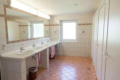 Camping Passrucker - Innenraum des Sanitärgebäudes mit Toilettenkabinen, Waschbecken und Spiegeln