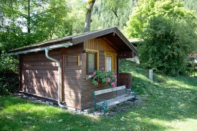 Camping Putterersee - Holzbungalow auf dem Campingplatz mit Bank davor