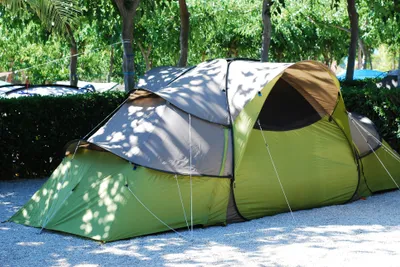 Camping Ribamar - Zelt auf einem Standplatz, welcher mit Kies ausgelegt und durch Hecken eingegrenzt ist