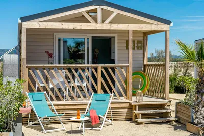Camping Sandaya Les Tamaris - Mobilheim mit Veranda und Liegestühlen auf dem Campingplatz