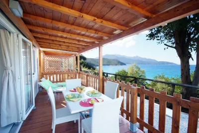 Camping Scaglieri  -  gedeckter Tisch und Liegestühle auf der Terrasse von einem Mobilheim auf dem Campingplatz