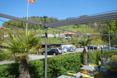 Camping Thörishaus  -  Restaurant vom Campingplatz mit Terrasse mit Blick auf den Parkplatz und grüne Hügel