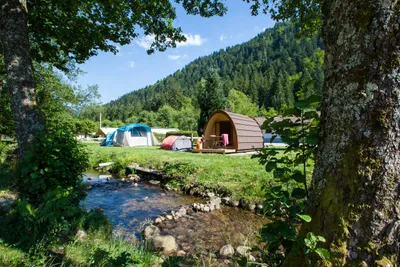 Flower Camping Verte Vallee  - Blick auf den Stellplatz und ein Mobilheim mit direktem Zugang zum Fluss am Campingplatz