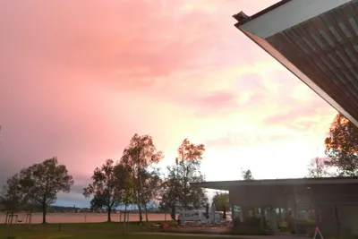 Campingplatz Hegne - Blick auf den Wohnwagen- und Zeltstellplatz und ein Gebäude des Campingplatzes mit dem Bodensee im Hintergrund