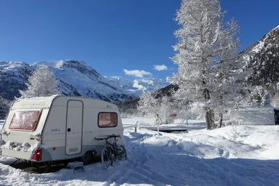 Camping Morteratsch - Wohnmobil im Schnee  mit Blick auf die Berge auf dem Campingplatz