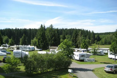 Camping Paulfeld - Luftaufnahme von Wohnwagen auf dem Stellplatz mit Wald im Hintergrund