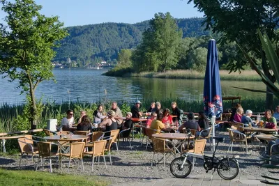 Campingplatz Schachenhorn - Aussenbereich des Restaurants mit Sitzgelegenheiten und essenden Campern