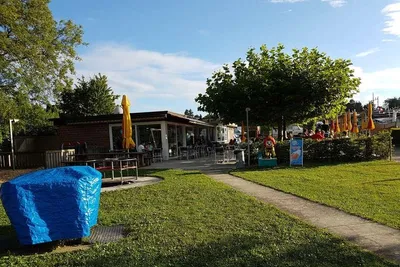Campingplatz Strandbad, Amriswil - Restaurant auf dem Campingplatz mit Terrasse, auf der Sitzgelegenheiten stehen