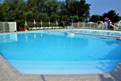 Camping Città di Angera - Poolbereich des Campingplatzes mit Liegestühlen und Sonnenschirmen