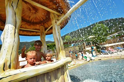 Camping Cros de Mouton  - Kinder auf dem  Spielplatz im Poolbereich vom Campingplatz