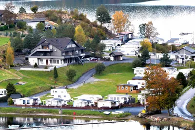 Egenes Camping  - Mobilheime, Wohnwagen und Hauptgebäude vom Campingplatz mit Blick auf den See