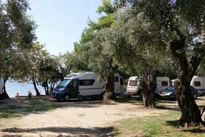 Camping Hellas  -  Wohnwagen- und Zeltstellplatz  zwischen Bäumen am Meer
