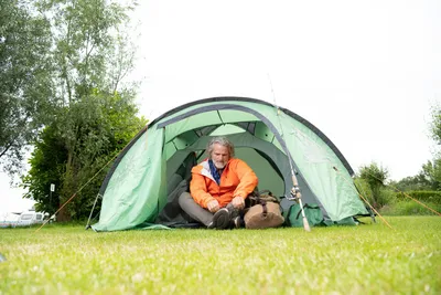 Camping Het Waterhoentje - Camper sitzt in seinem Zelt auf dem Campingplatz